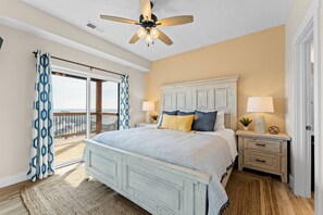 A bedroom with a bed, two bedside tables, a ceiling fan, and a view through a sliding glass door to the outside. - Stunning view-Hot Tub-Game Room-Indoor Pool Access (Branson)