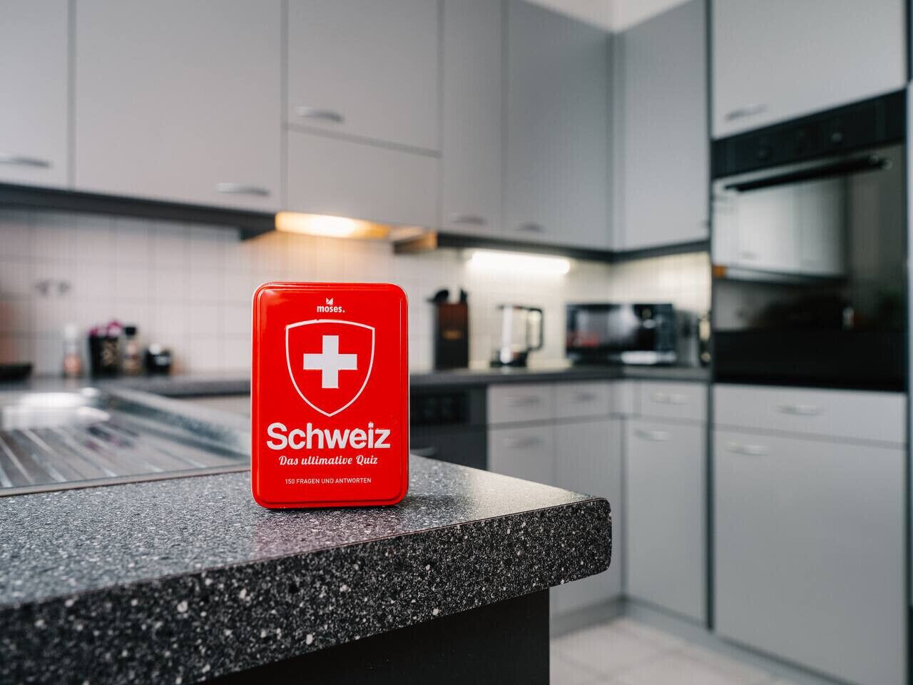 A red box with a white cross and the word "Schweiz" on a kitchen counter.