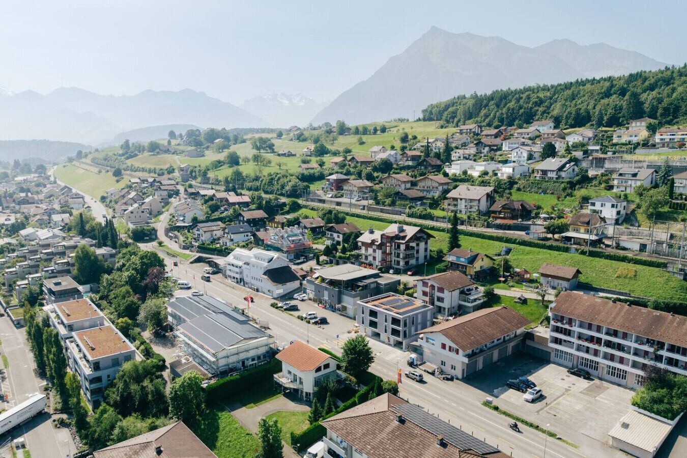 Vista aérea de una zona residencial con casas, caminos y una montaña al fondo.