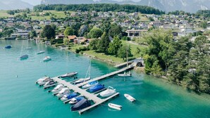 An aerial view of a lakeside town with a marina, houses, and mountains in the background. - Apartment Eiger with lake and mountain view (Spiez)