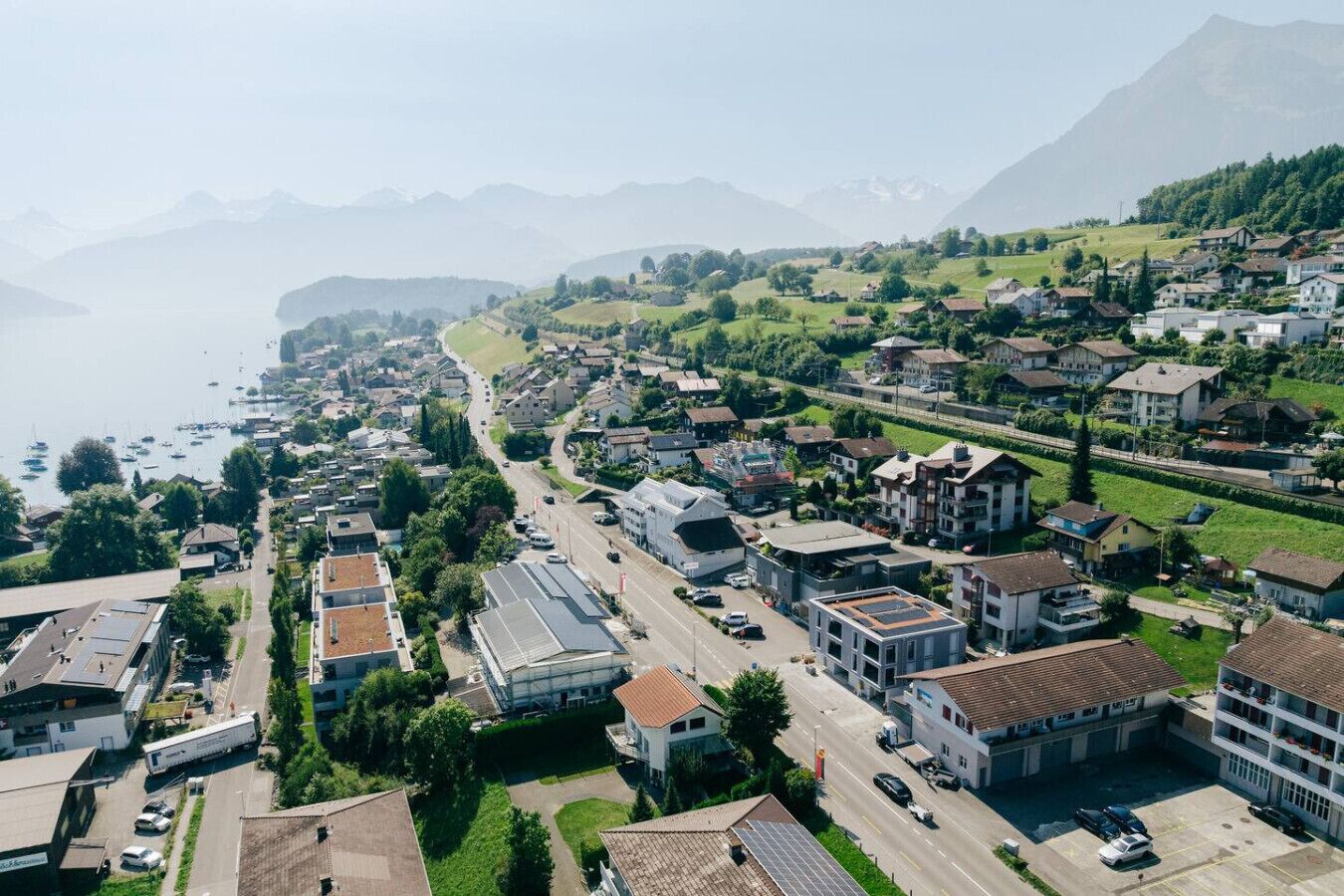 An aerial view of a coastal town with residential buildings, roads, and a marina.
