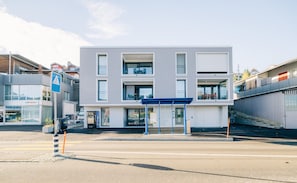 Un edificio moderno con techo plano, ventanas amplias y una zona de entrada cubierta.