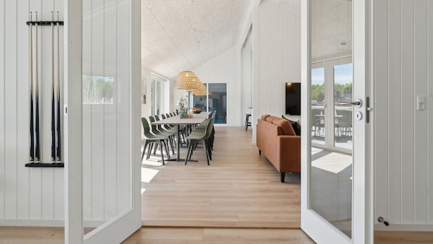 Un intérieur moderne comprenant un coin repas, un canapé et un téléviseur.