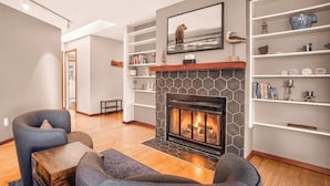 A living room with a fireplace, bookshelves, and a comfortable seating area.