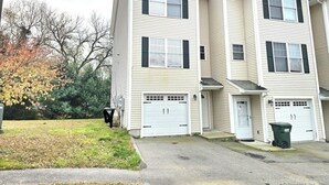 A two-story apartment building with a central entrance and two garages.