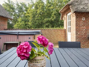 A patio with a table, chairs, and a basket of flowers. - 4 Star Holiday Home in Ulfborg (Ulfborg)