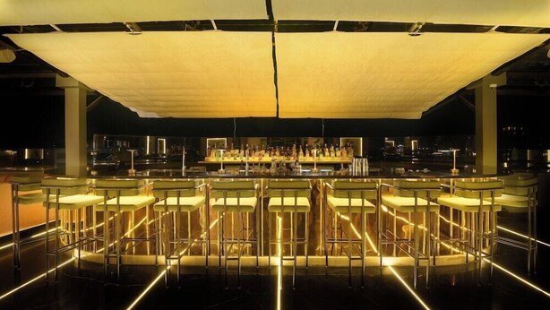 A bar area with multiple bar stools and a bar counter. - Hotel Le Himalaya (Kathmandu)