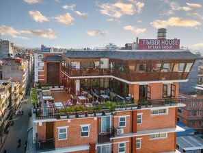 Un edificio a più piani con un cartello che riporta la scritta "TIMBER HOUSE BY TARA GROUP".