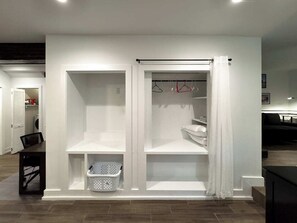 A white walk-in closet with open doors, shelves, and hanging space. - Newly Furnished 1-BR/1-BA in Atlanta's Virginia Highland Neighborhood (Atlanta)