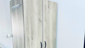 Ein Schrank mit heller Holzoptik und zwei schwarzen Griffen.