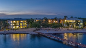 A beachfront hotel with multiple buildings, a sandy beach, and a water body.