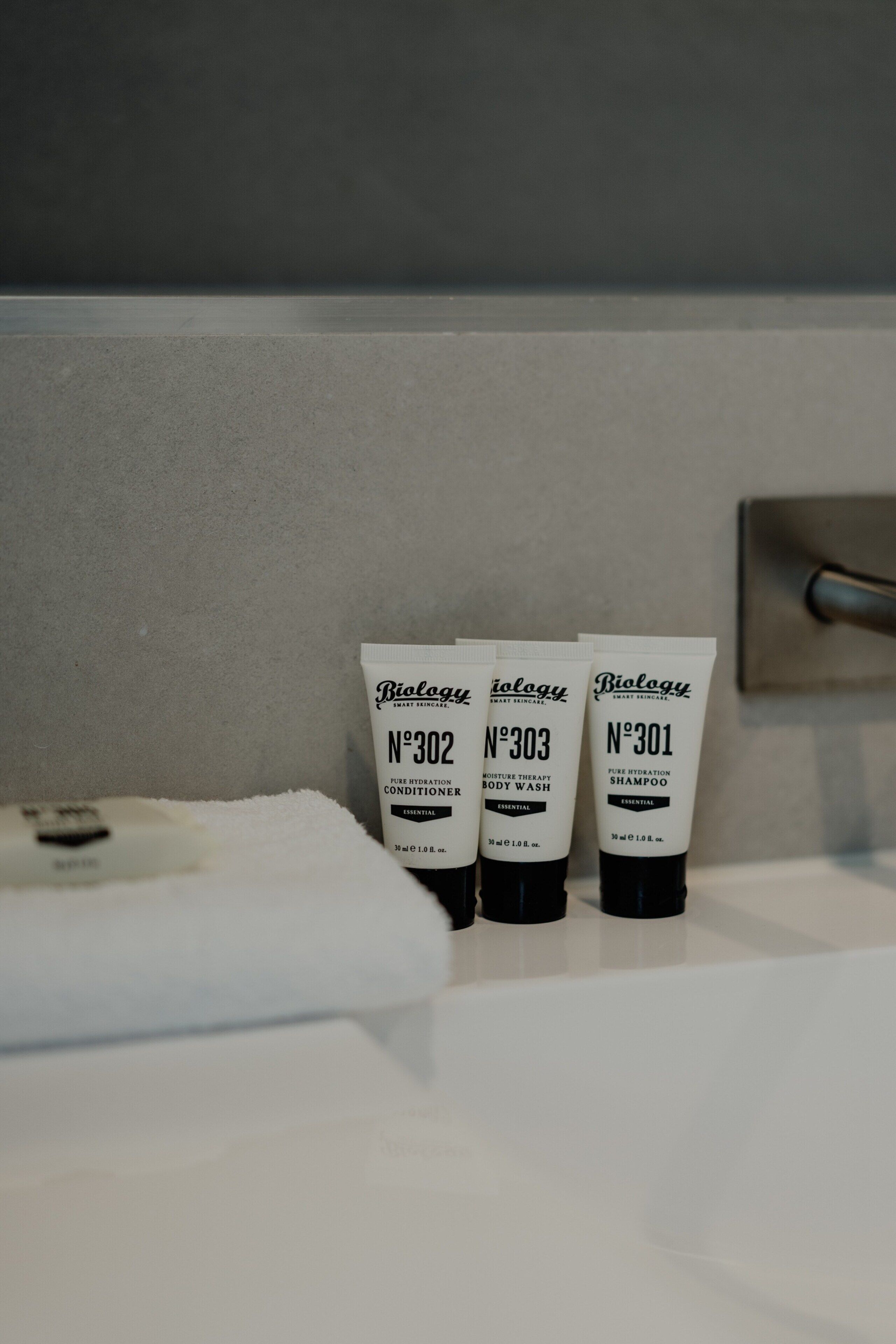 Three toiletries labeled N°302, N°303, and N°301 on a bathroom sink.