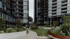 Et moderne byområde med højhuse, en anlagt have og en træterrasse.