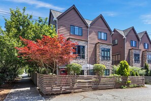 A row of modern houses with a stone facade, a wooden fence, and a pathway leading to the entrance. - Green Lake Modern K/Q  + Parking | Stadium Access (Seattle)