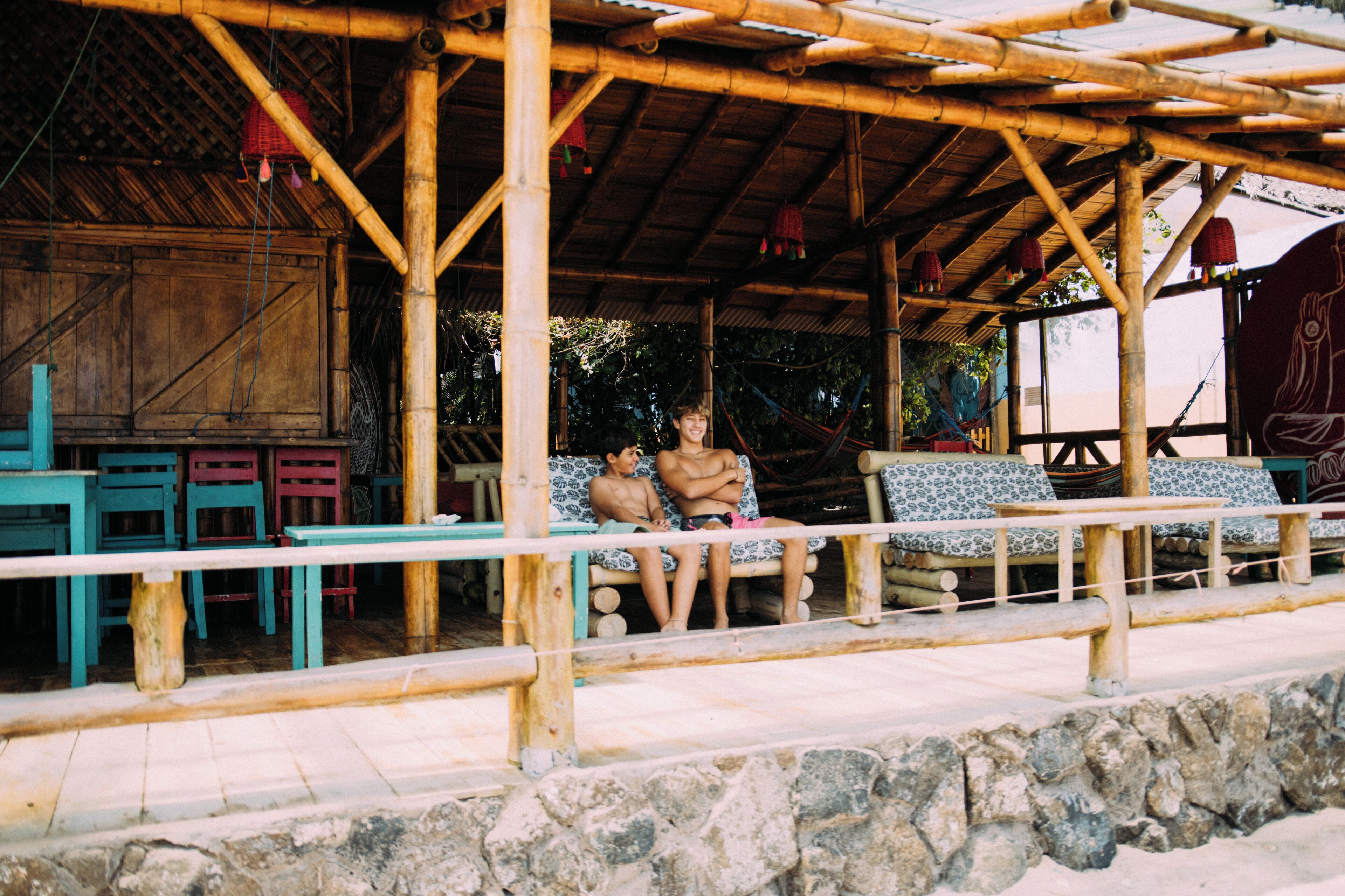 A bamboo structure with seating and tables, suggesting a communal outdoor area.