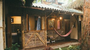 A rustic wooden cabin with a thatched roof, a hammock, and a small porch area. - HOSTAL ROSA MISTICA  (Montañita)