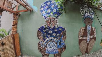 A mosaic mural of a figure with a large headdress on a wall.