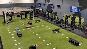 A gym with green turf, weightlifting equipment, and exercise machines. - Luxury Downtown Apt with Parking, Gym, and Lap Pool · Sleeps 4-5 (Milwaukee)