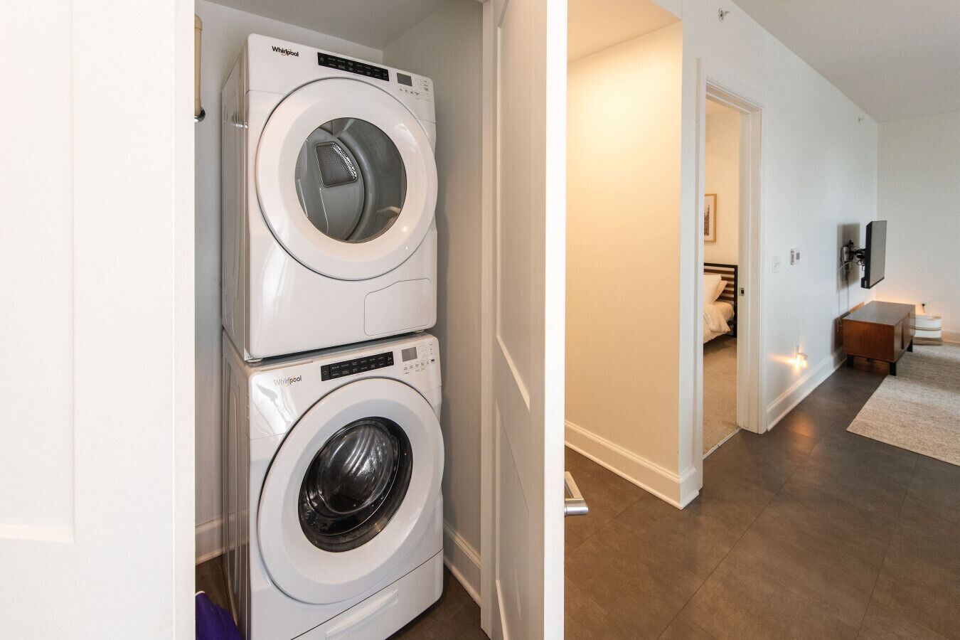 A laundry room with two stacked Whirlpool front-loading washers.