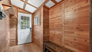 Un intérieur en bois avec une porte, un banc et des fenêtres.