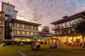 Un hotel con varios pisos, espacios al aire libre para sentarse y un patio bien iluminado.