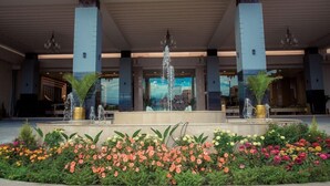 A hotel lobby with a central fountain, large columns, and a variety of colorful flowers. - The Everest Hotel (Kathmandu)