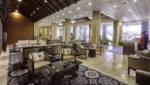 A spacious lobby with high ceilings, multiple seating areas, and a reception desk. - The Everest Hotel (Kathmandu)