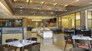 A modern restaurant with a checkered floor, multiple dining areas, and a central bar. - The Everest Hotel (Kathmandu)