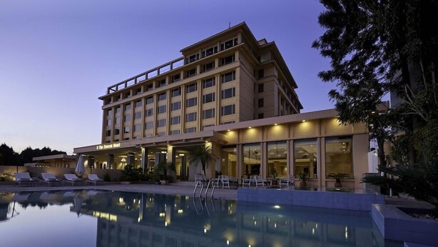 A hotel with a swimming pool, outdoor seating, and a well-lit facade. - The Everest Hotel (Kathmandu)