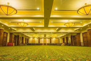 A large conference room with a patterned carpet, wooden doors, and multiple chandeliers. - The Everest Hotel (Kathmandu)