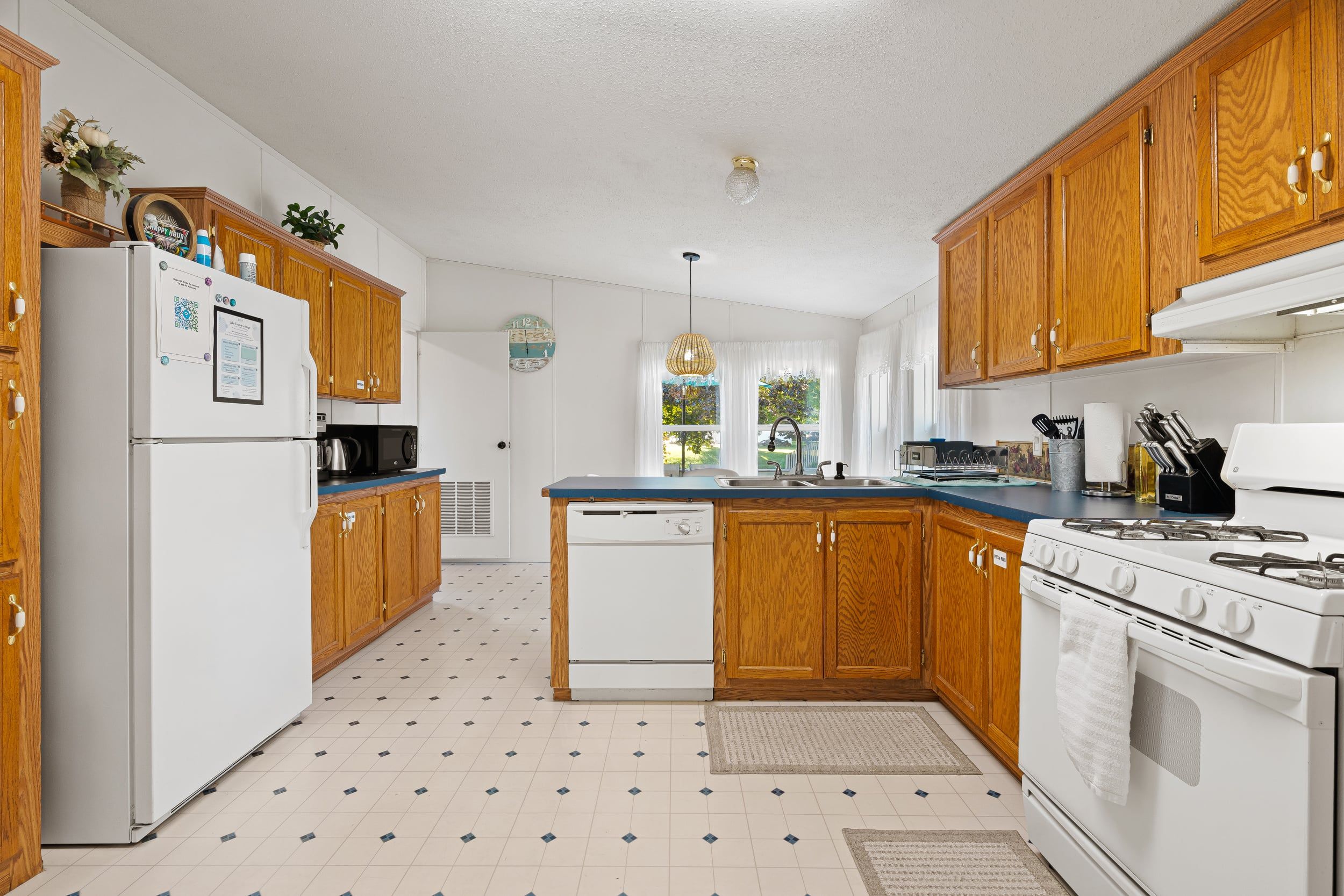 A kitchen with wooden cabinets, a white refrigerator, a stove, and a microwave.