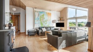 A spacious living room with a large map, a fireplace, and a large window. - Nice home in Tarm with sauna (Tarm)