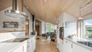 A modern kitchen with white cabinetry, stainless steel appliances, and a wooden ceiling. - Nice home in Tarm with sauna (Tarm)