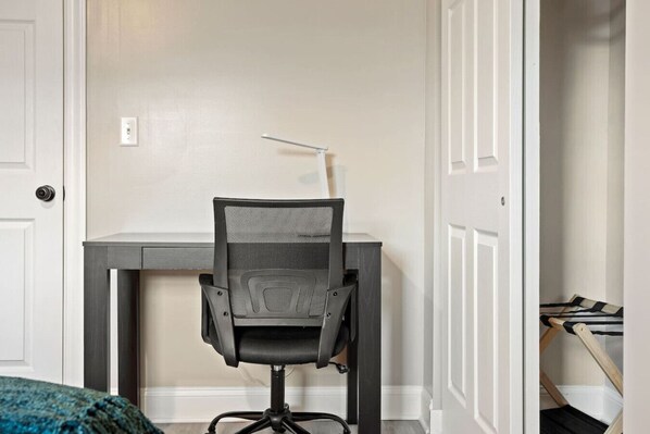 A small office space with a desk and a mesh office chair.
