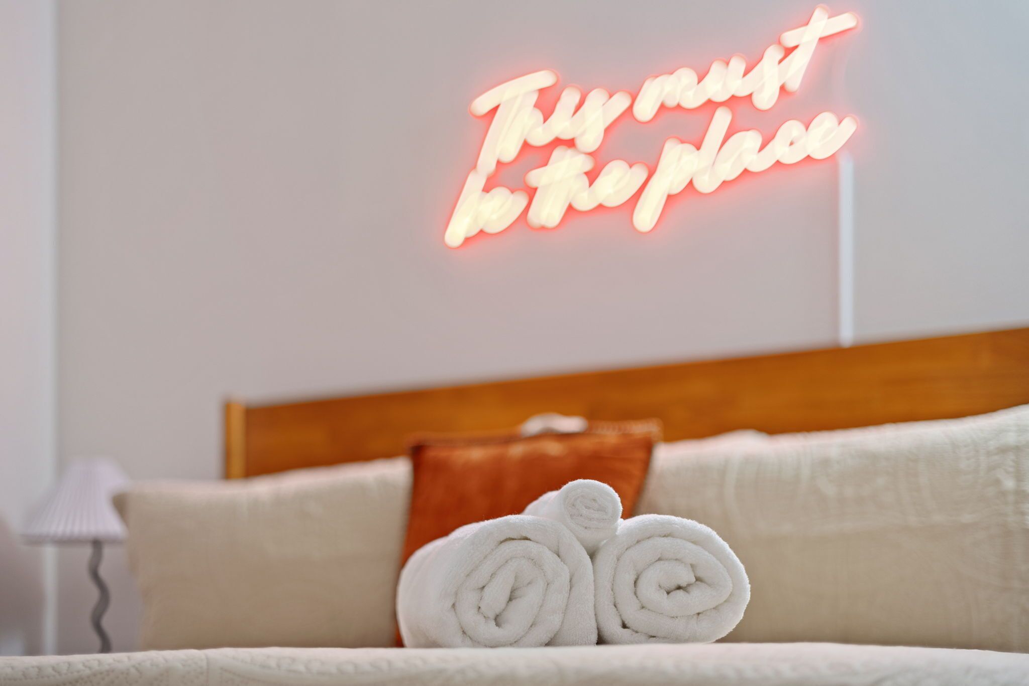 Un lit bien fait, avec des serviettes blanches pliées en rouleaux, et un panneau lumineux au néon sur lequel on peut lire : « C’est ici, c’est sûr. »