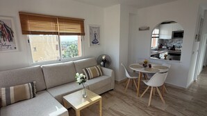 Una sala moderna con sofá, mesa de centro y comedor.
