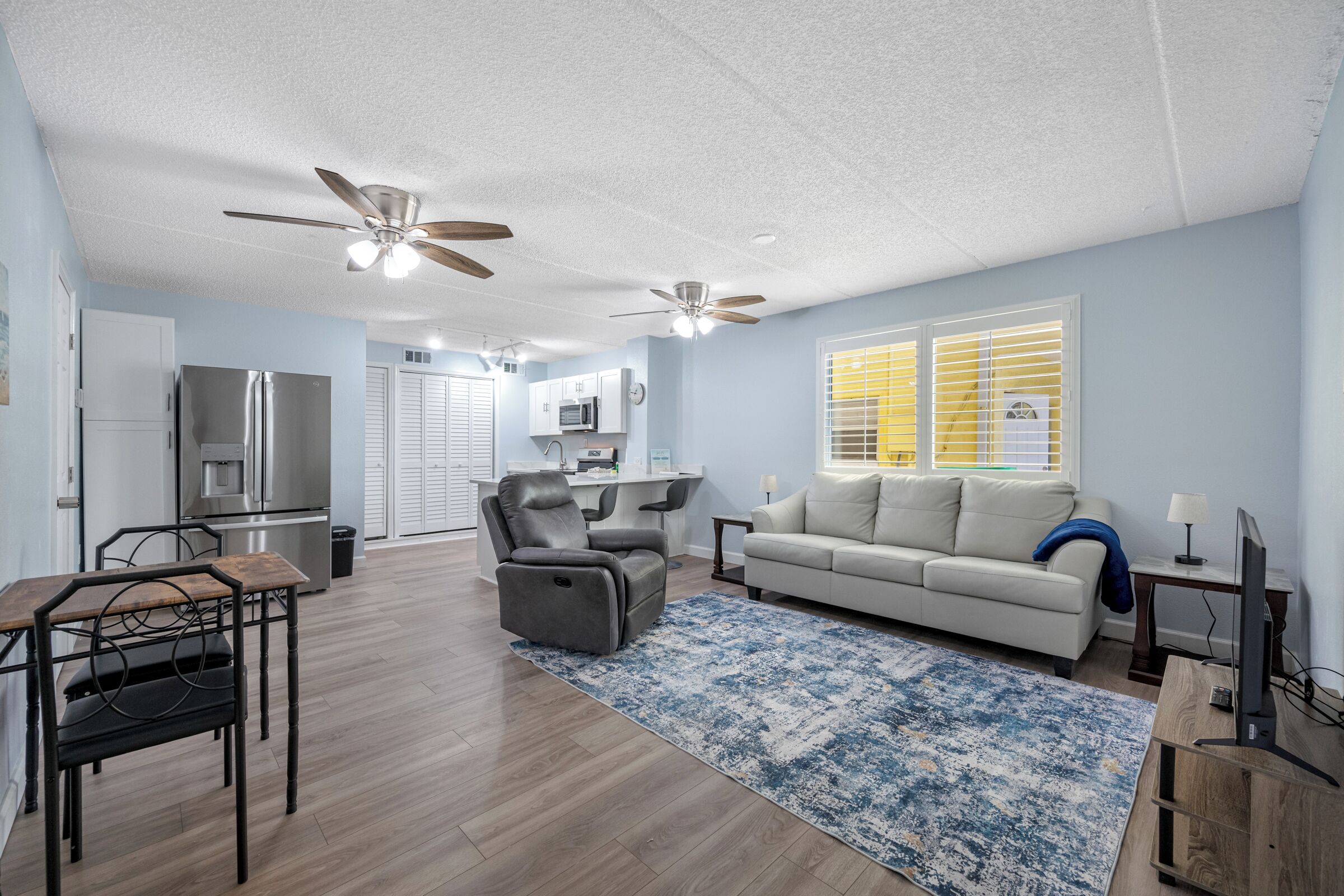 A spacious living area with a kitchen, dining table, and seating.