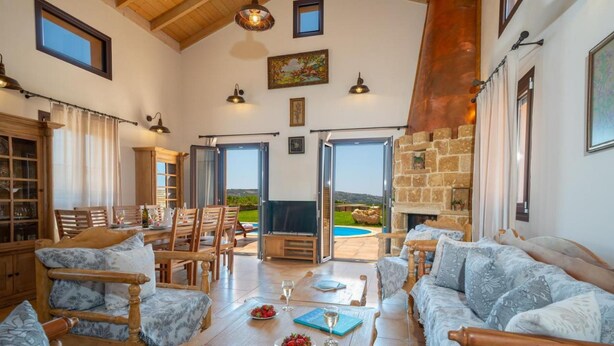 Amplia sala de estar con chimenea, una mesa de comedor con sillas y un sofá.