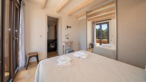Un dormitorio con una cama grande, una lavadora y una puerta corredera que da a un área exterior.