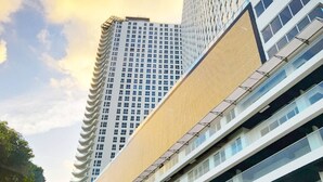 A modern high-rise building with multiple floors, large windows, and a prominent entrance area. - Balboa Avenue Sky Suites (Panama City)
