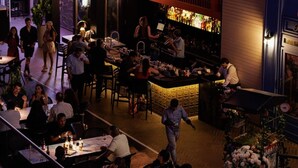A bar area with tables and chairs, a television screen, and a bar counter. - Balboa Avenue Sky Suites (Panama City)