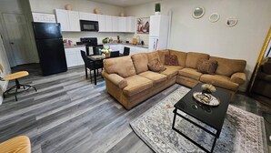 Espaço compacto com cozinha, área de jantar e sofá.