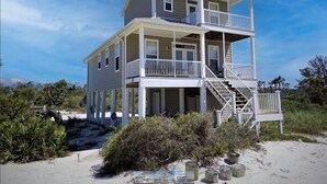 A two-story beachfront house with a balcony and a staircase leading to the upper floor. - Gulf View - 3 bed/3.5 bath Cape San Blas FL. Pet friendly! (Port St. Joe)