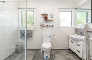 Une salle de bain moderne équipée de toilettes, d’un lavabo et d’une douche.