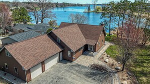 A two-story house with a garage, a driveway, and a view of a lake.