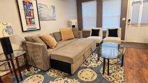 A living room with a sofa, two armchairs, a coffee table, and a patterned rug. - Enchanting 2-bedroom, Sleeps 6, in Heart of Highlands-Nulu-Bardstown Road (Louisville)