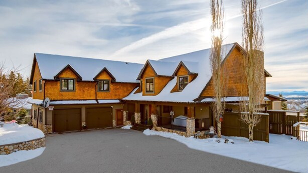 Une grande maison à plusieurs étages, dont le toit est recouvert de neige et les fondations sont en pierre.