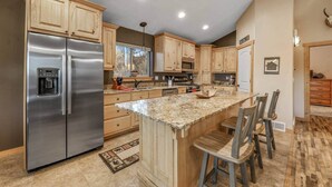 A modern kitchen with wooden cabinets, stainless steel appliances, and a granite countertop. - Moose Mountain Lodge Above Park City (Summit County)