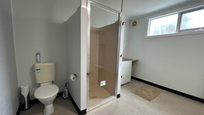 A small, clean bathroom with a toilet, a shower, and a sink.