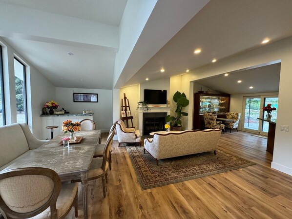 A spacious living area with a dining table, sofas, and a fireplace. - Charming 3-bedroom GARDEN COTTAGE in Fillmore with 1 acre rose garden access (Fillmore)